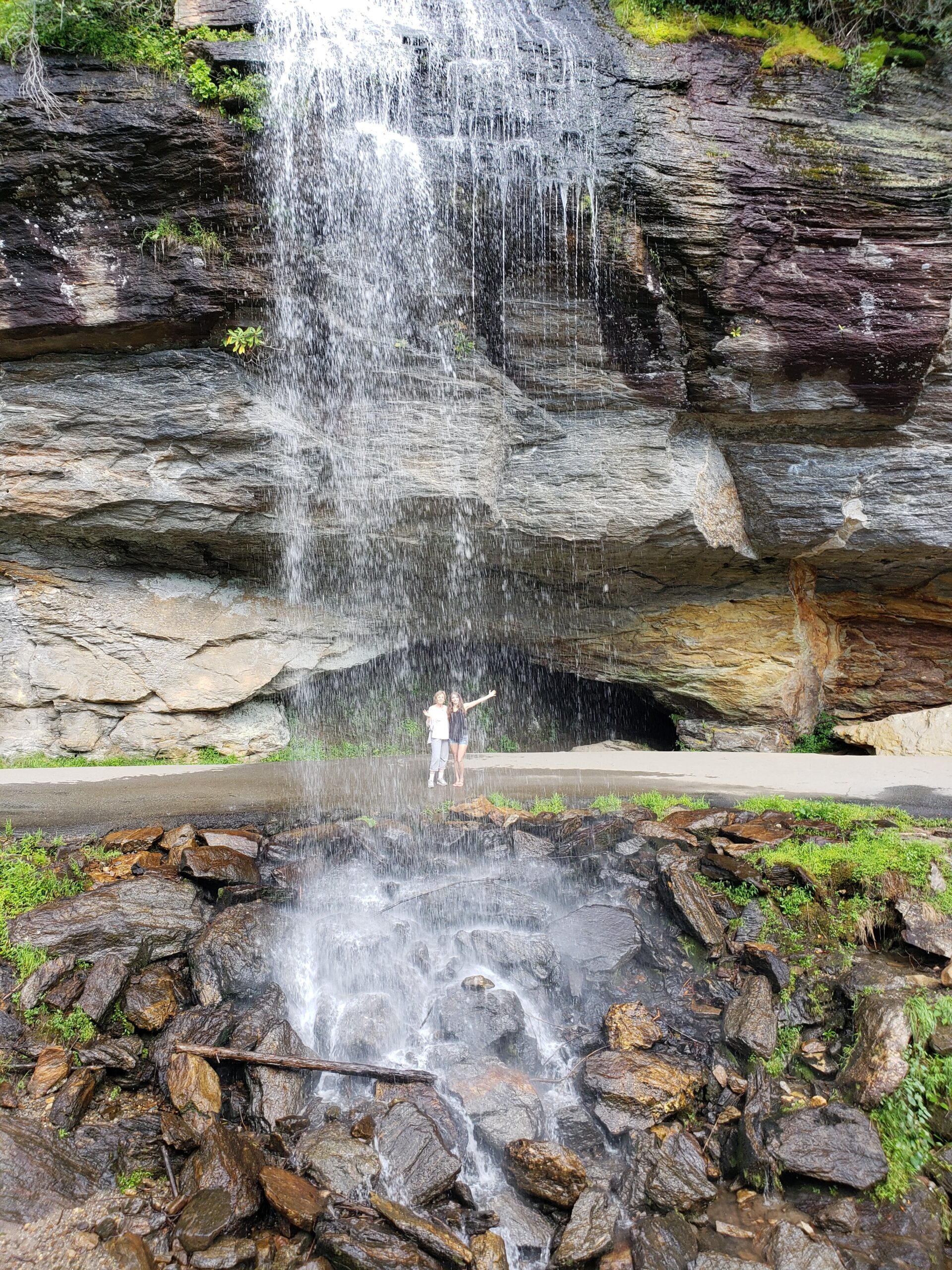 Soco Falls twin cascades dropping over 100 feet into a rocky gorge with morning sunlight filtering through trees near Maggie Valley NC