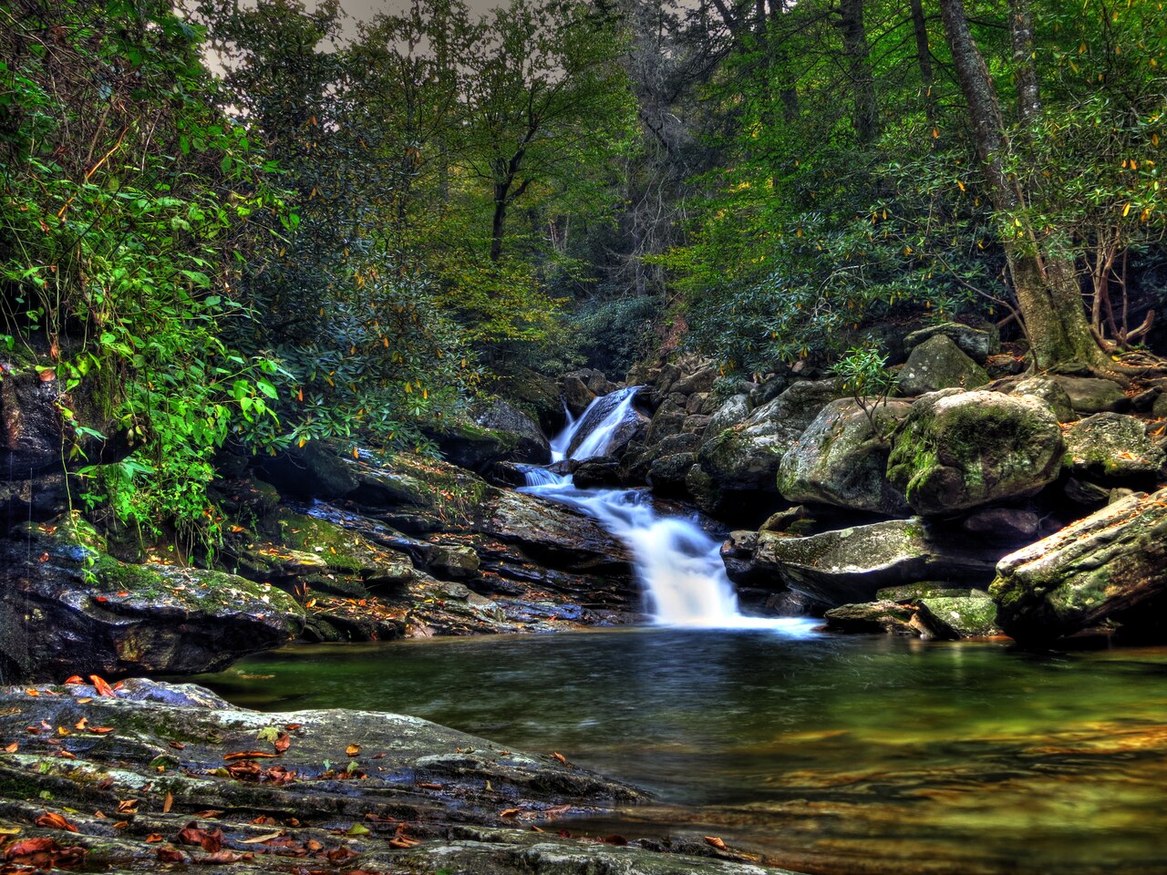 Skinny Dip Falls cascading waterfall flowing into clear swimming pools along the Blue Ridge Parkway near Waynesville NC
