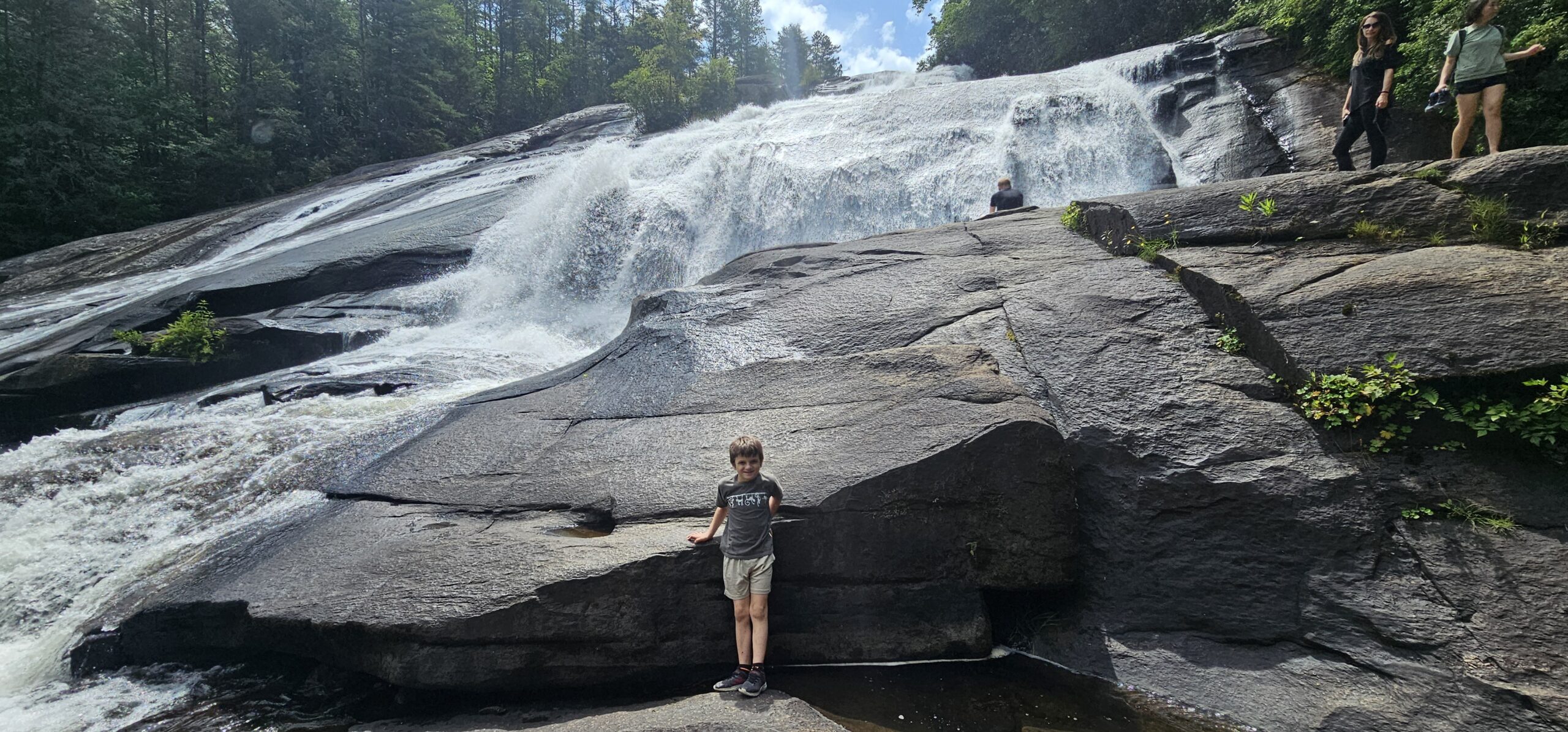 Young boy standing at the overlook viewing the 150-foot High Falls in DuPont State Forest near Brevard NC