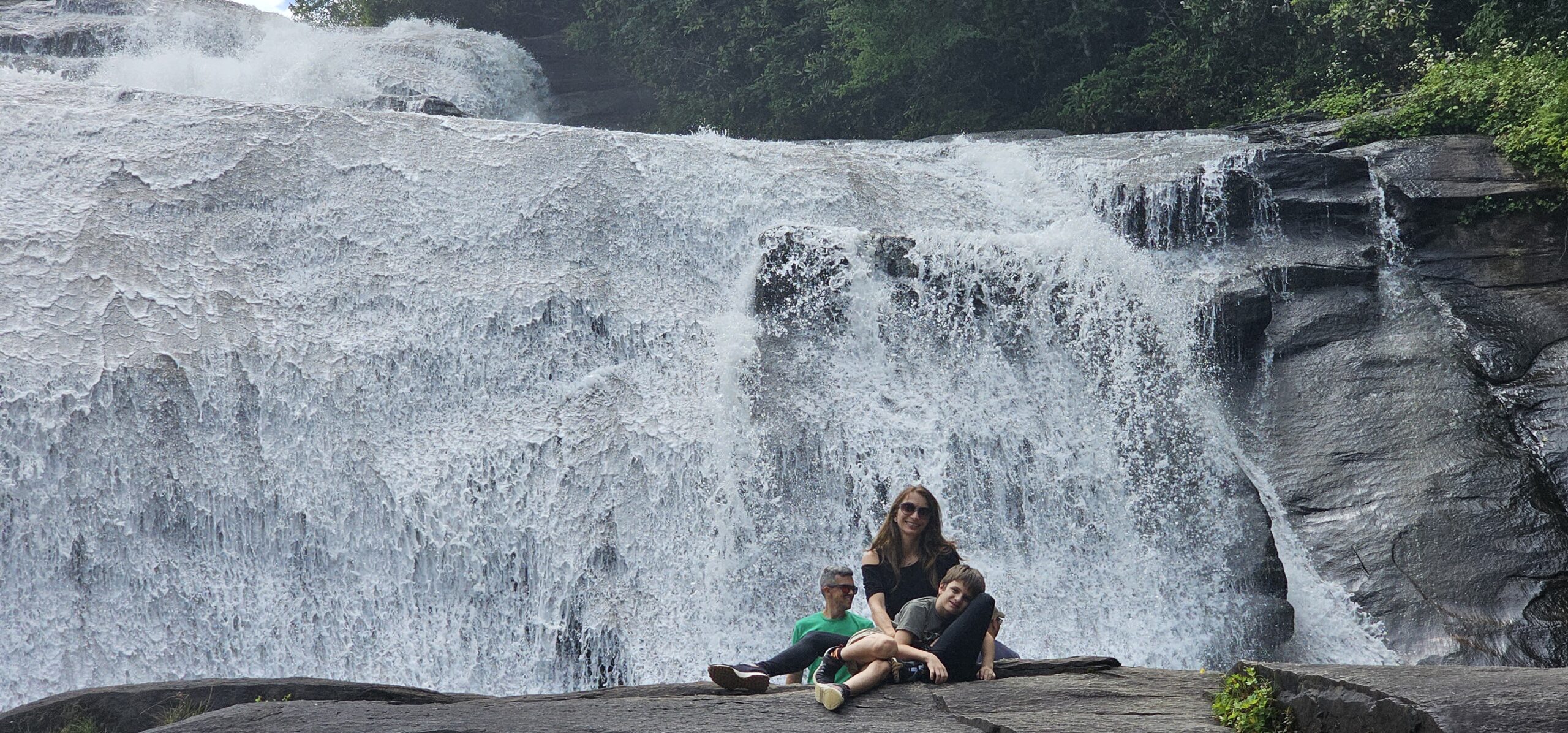 Mother and children posing at the High Falls overlook in DuPont State Forest with the massive waterfall in the background
