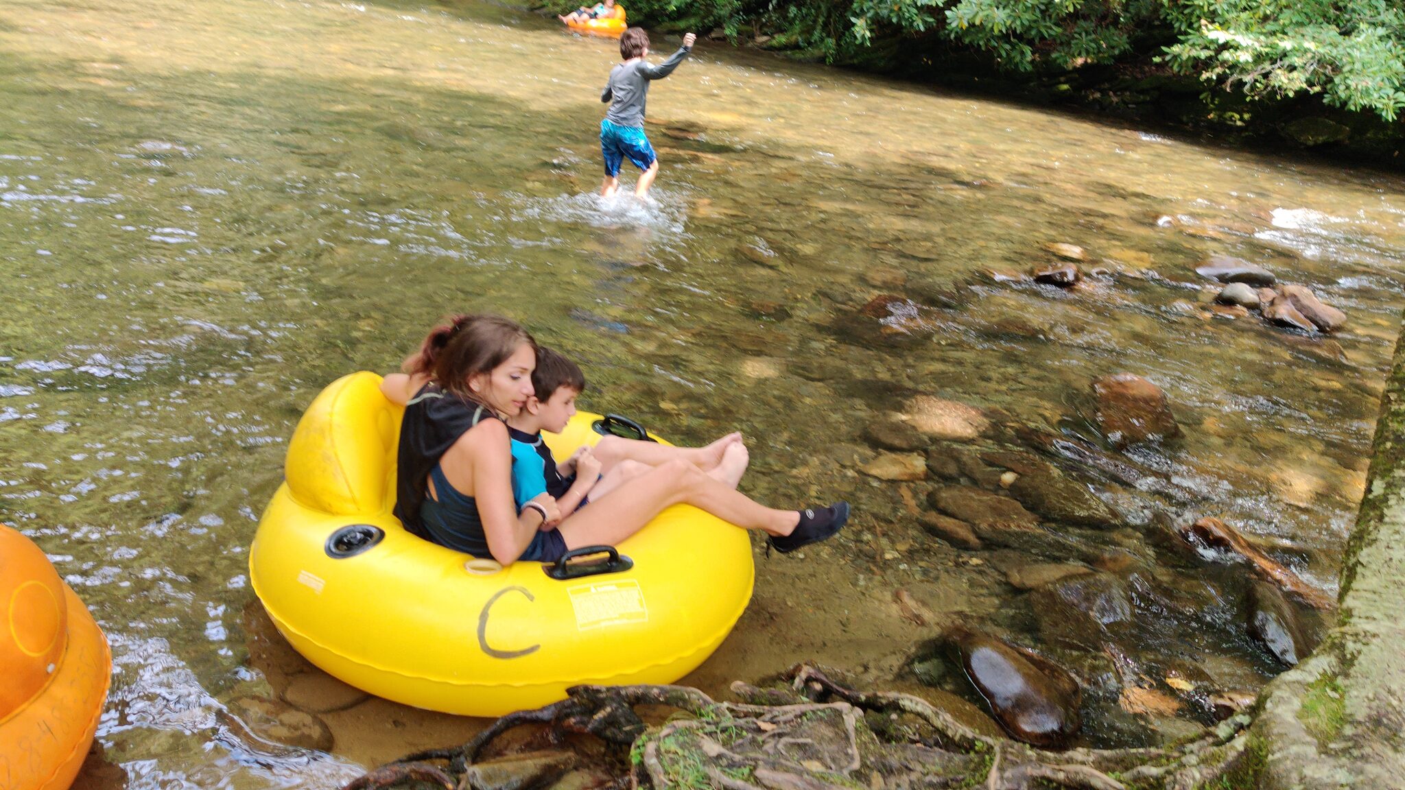 Family tubing down Deep Creek in the Great Smoky Mountains on a sunny summer day
