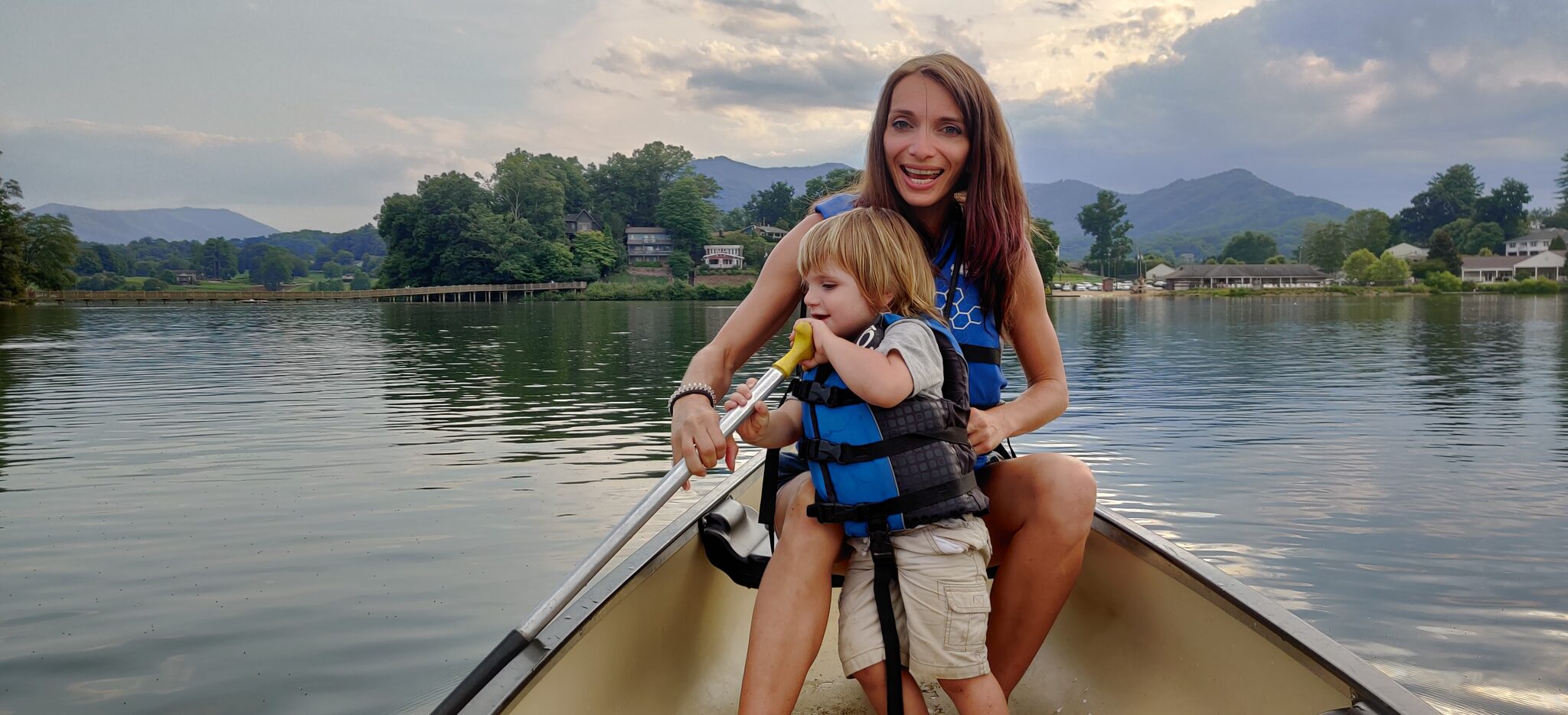 Family canoeing on Lake Junaluska with mountain views near Waynesville NC