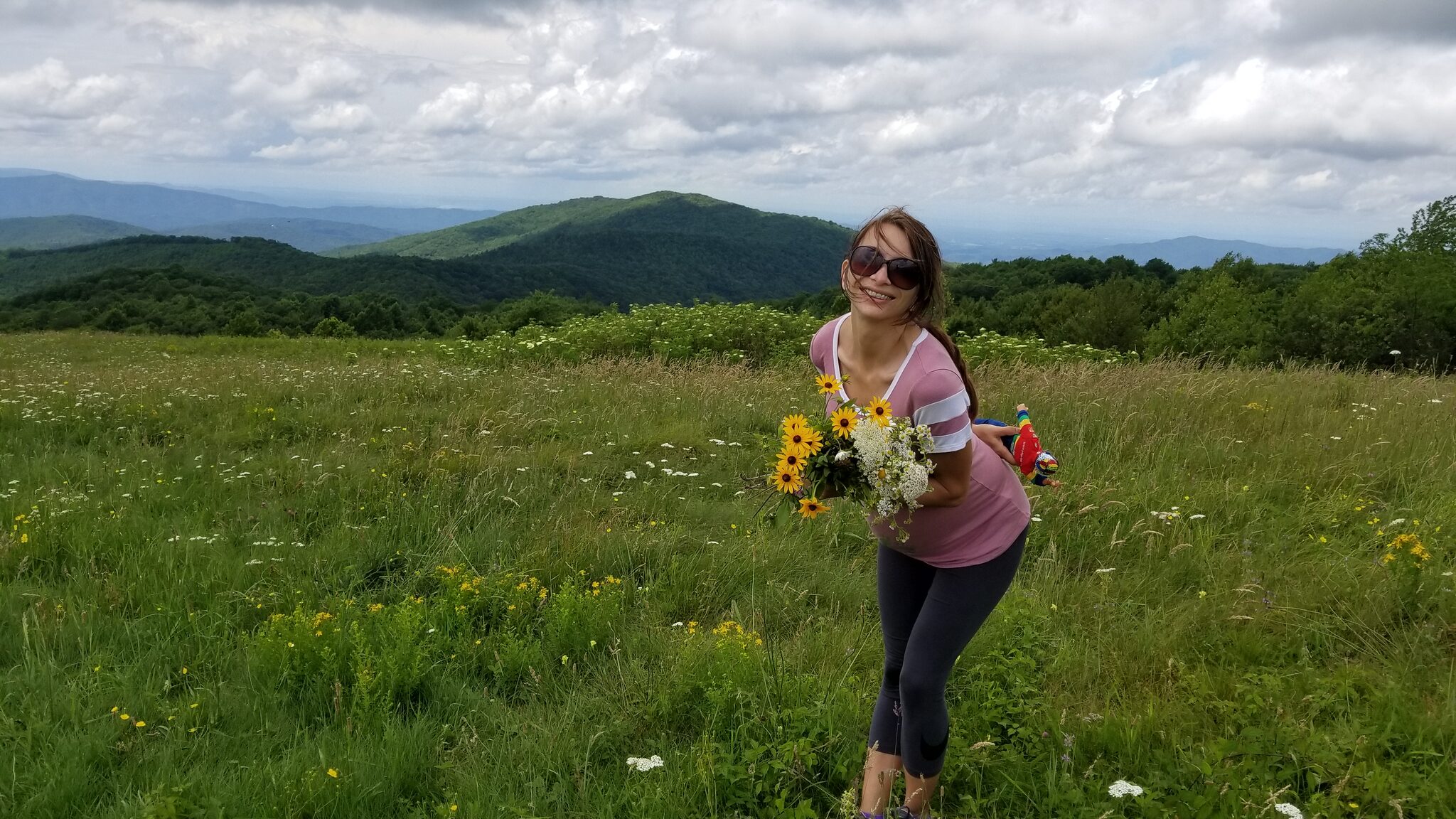 Hiker with wildflower bouquet on the Max Patch summit meadow