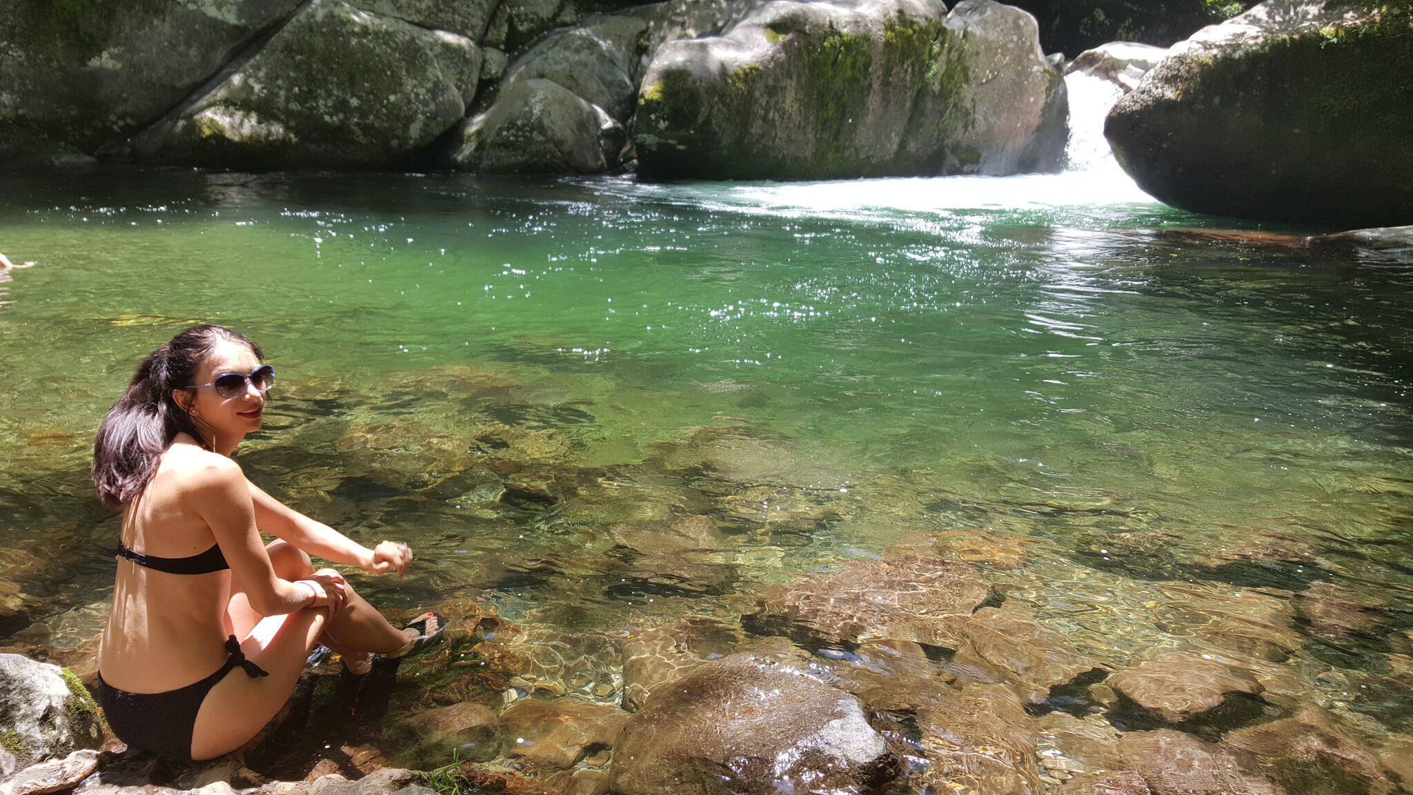 Relaxing by the crystal clear pool at Midnight Hole surrounded by massive boulders