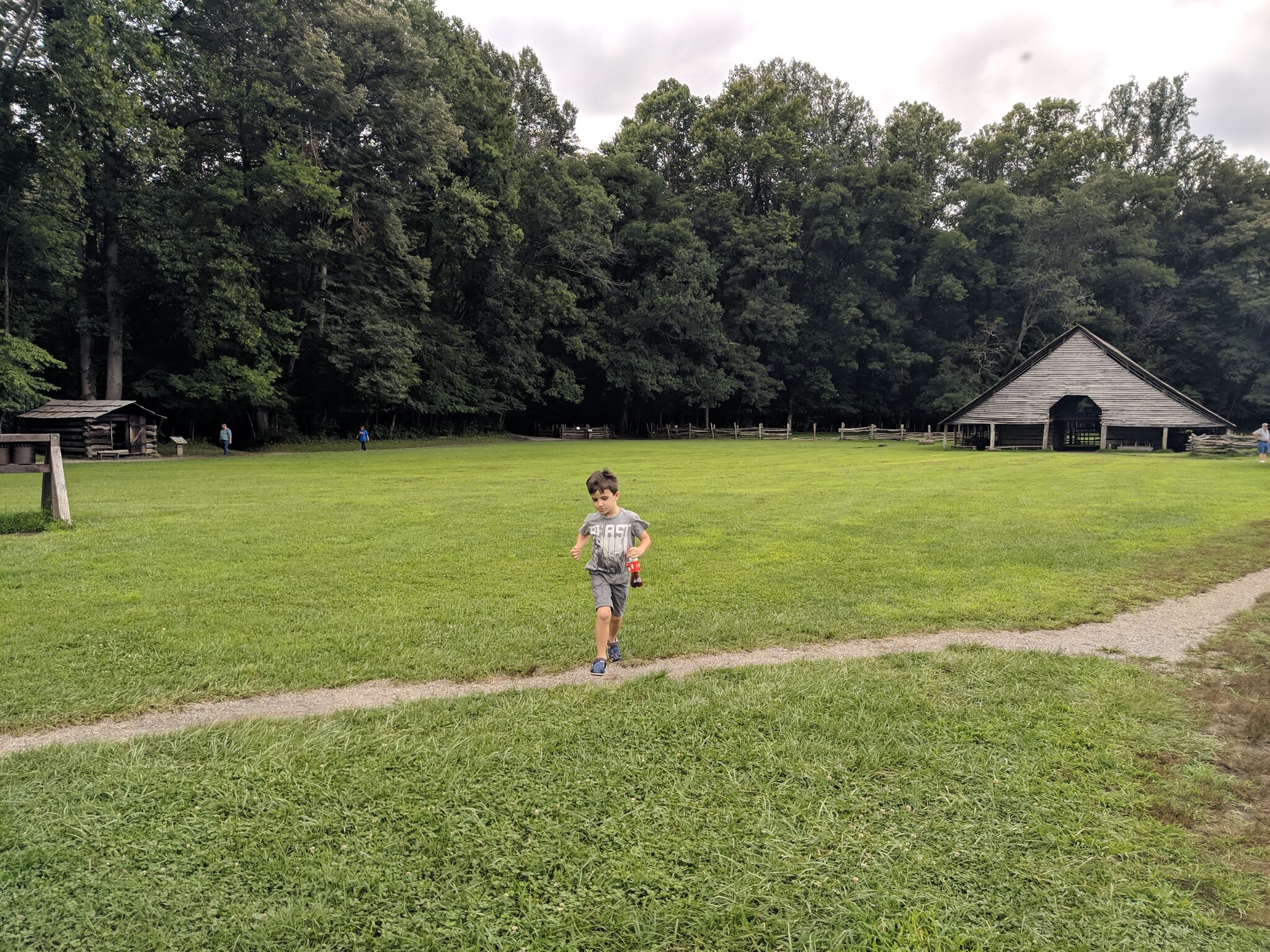 Child running across the open grounds at the Mountain Farm Museum at Oconaluftee Visitor Center