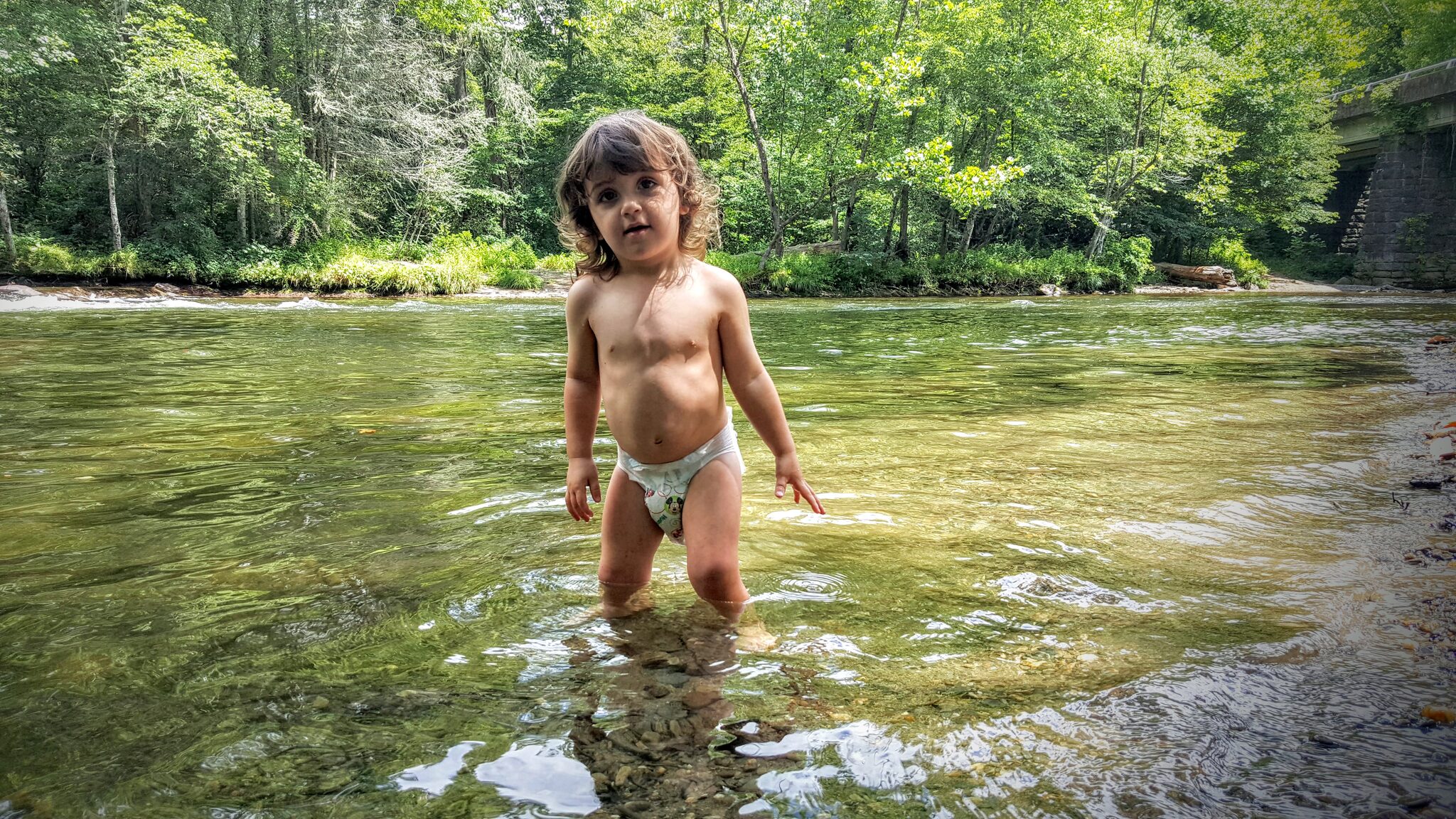 Toddler wading in the crystal clear Oconaluftee River in Great Smoky Mountains National Park