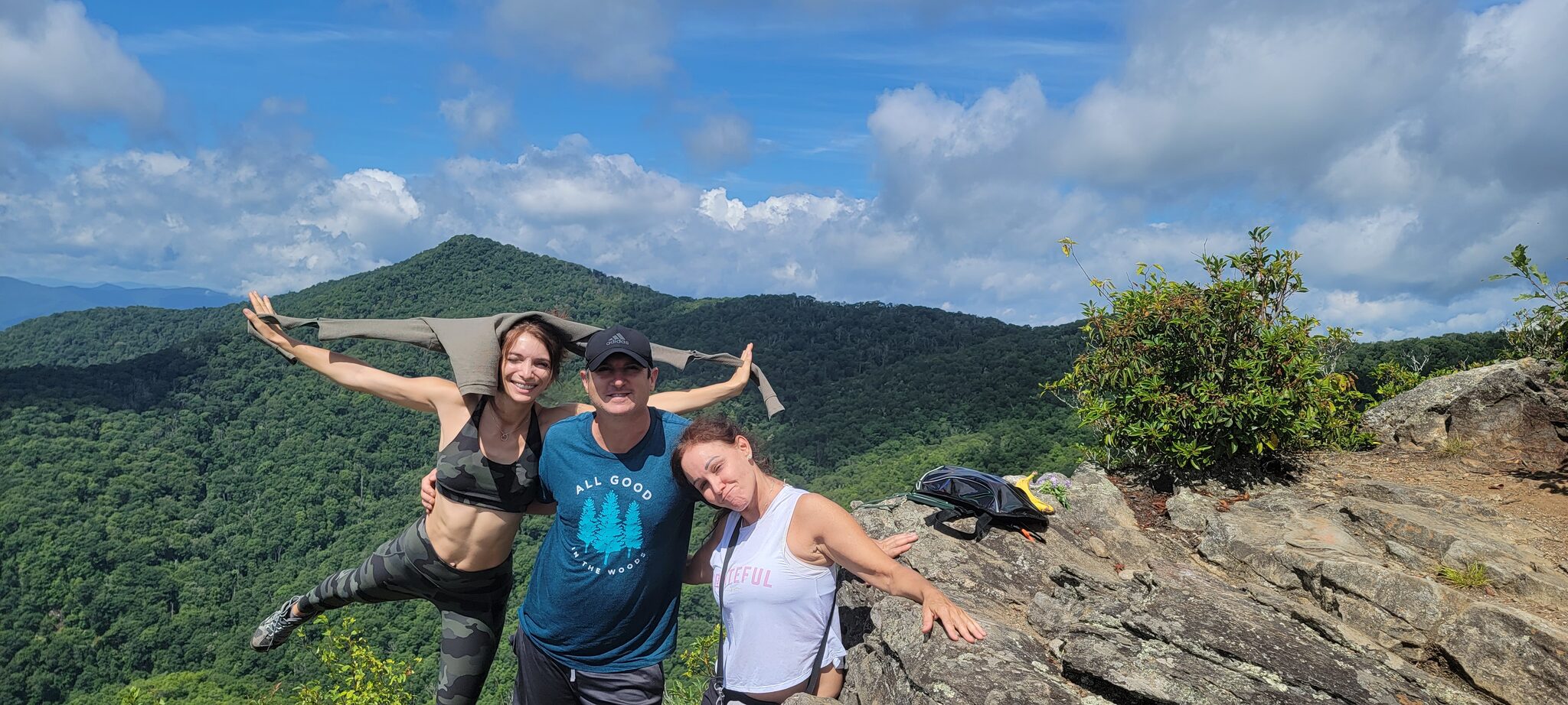 Group celebrating at The Pinnacle summit with Blue Ridge Mountain backdrop