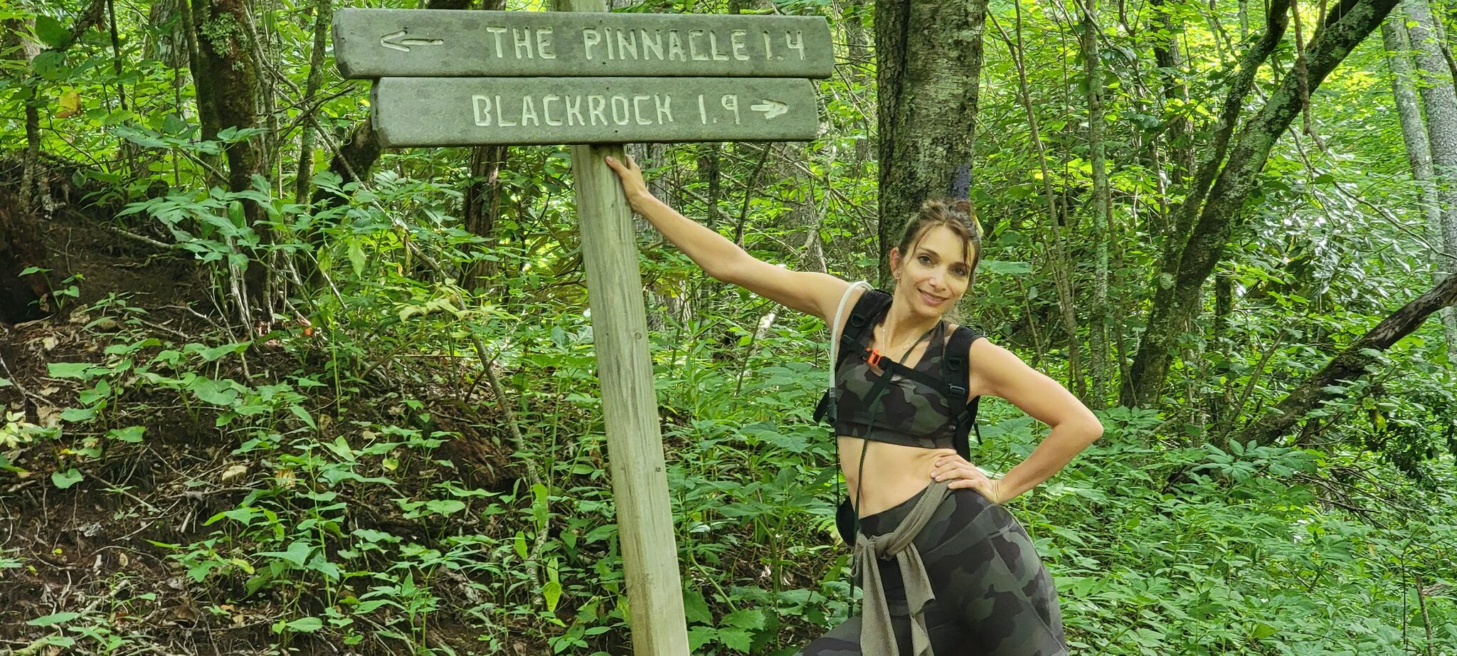 Hiker posing at The Pinnacle trail sign near Waynesville NC