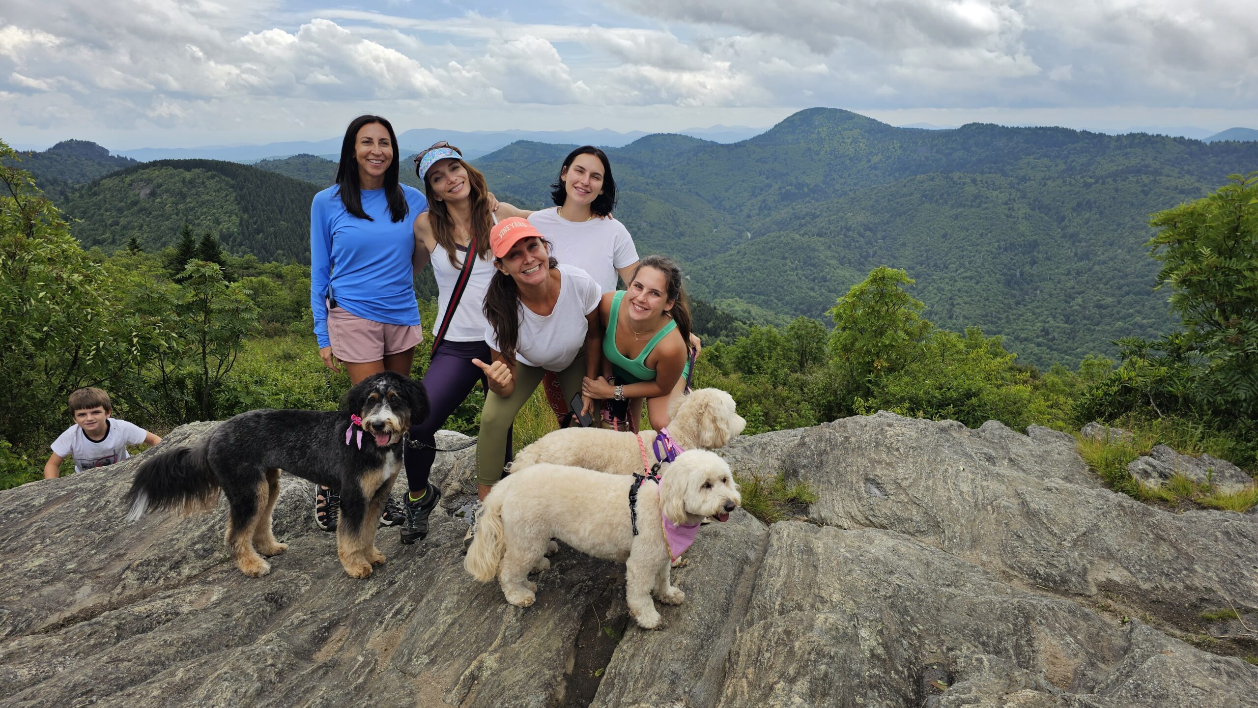 Family group with dogs on Sam Knob summit overlooking Blue Ridge Mountains near Waynesville NC