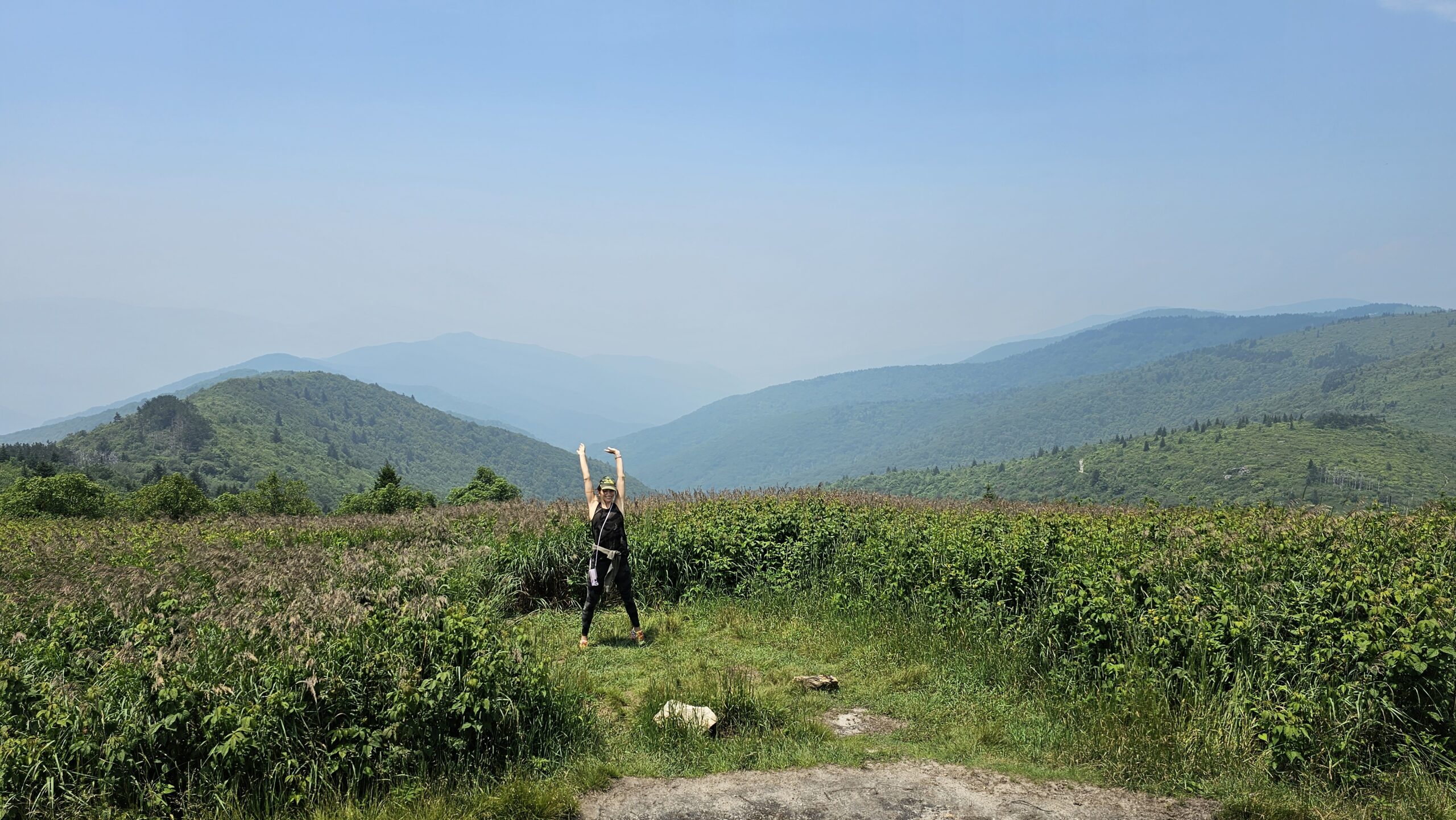 Hiker walking through wildflower meadow on Ivestor Gap Trail to Tennent Mountain near Blue Ridge Parkway