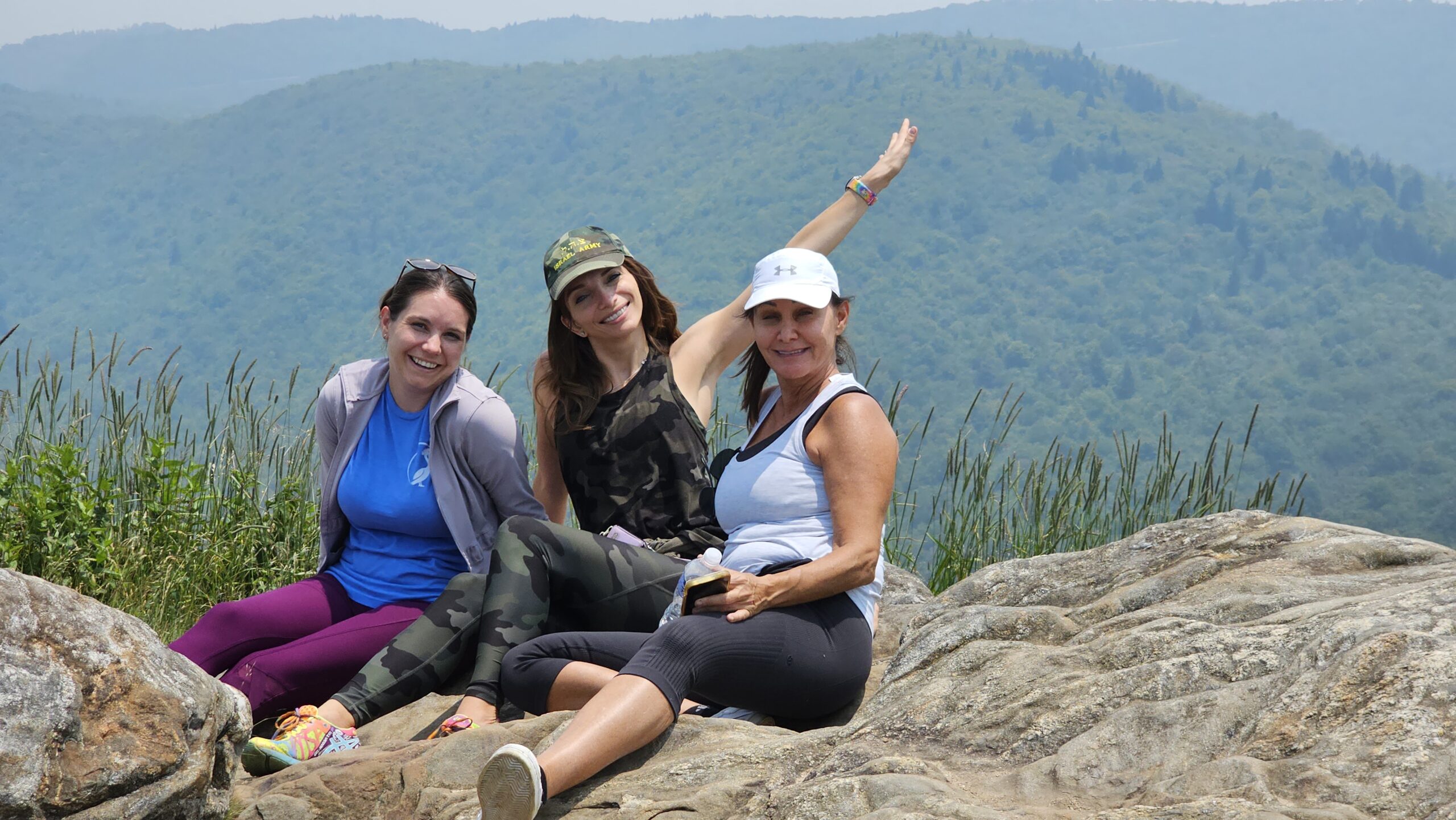 Friends posing on Tennent Mountain summit with Blue Ridge Mountains in the background