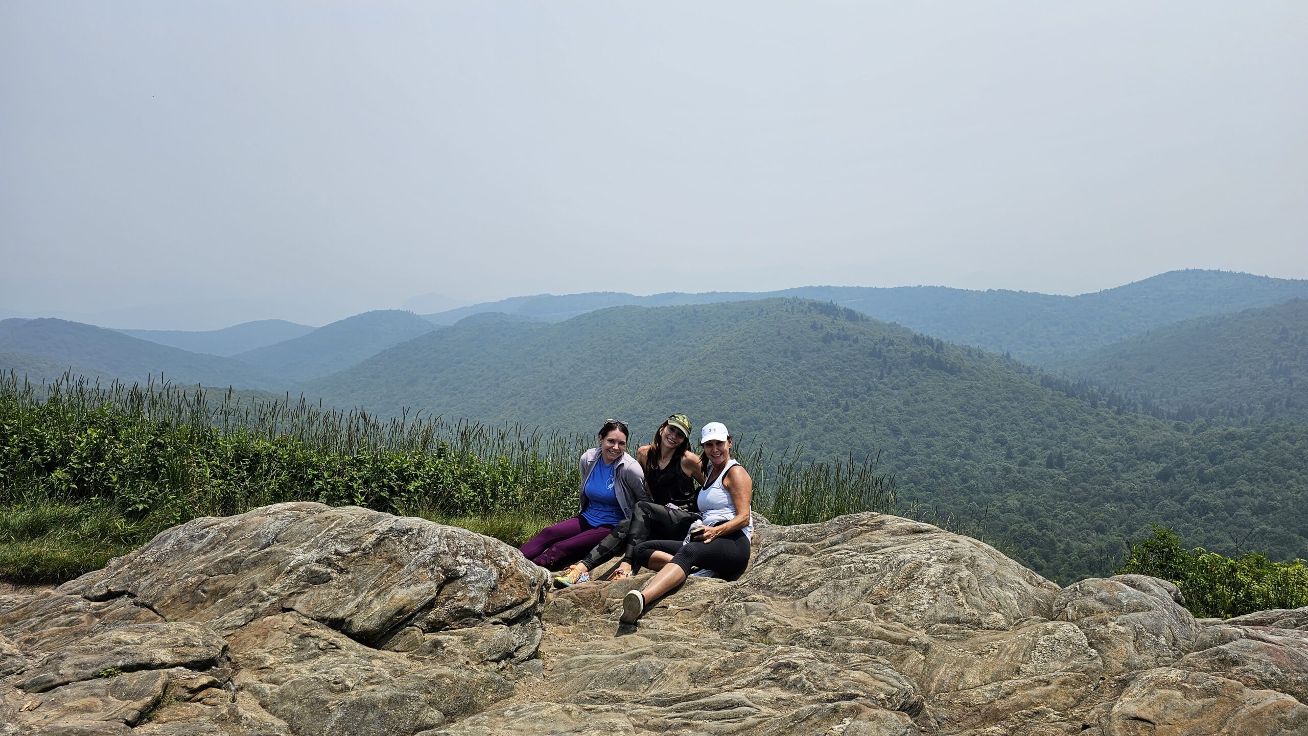 Group of hikers on Tennent Mountain rocky summit overlooking the Shining Rock Wilderness